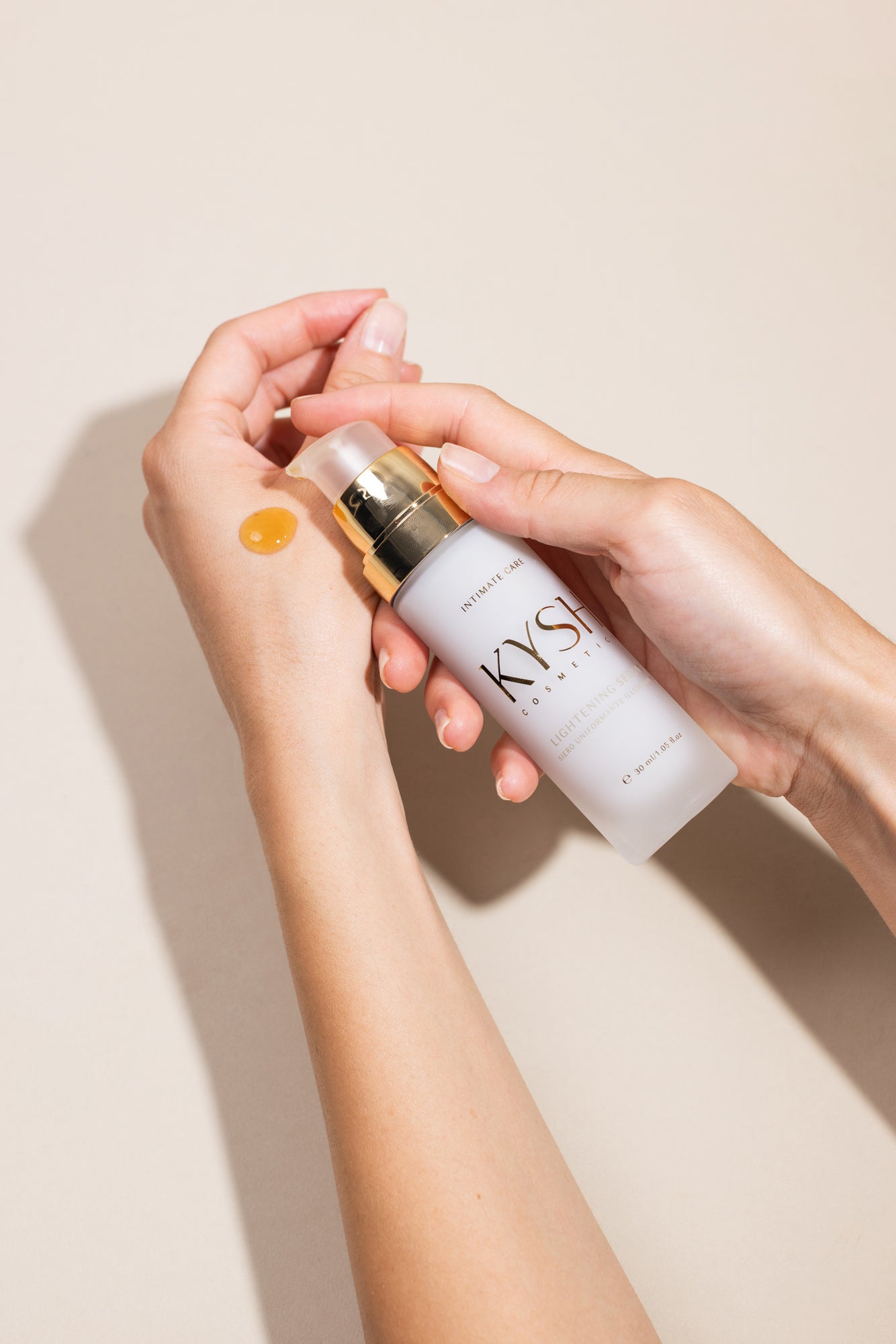 Person holding a KYSH lightening serum product with a beige background