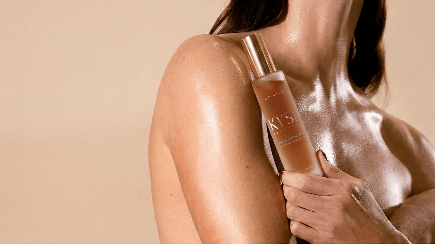 Person holding a bottle of KYSH skincare product against a beige background